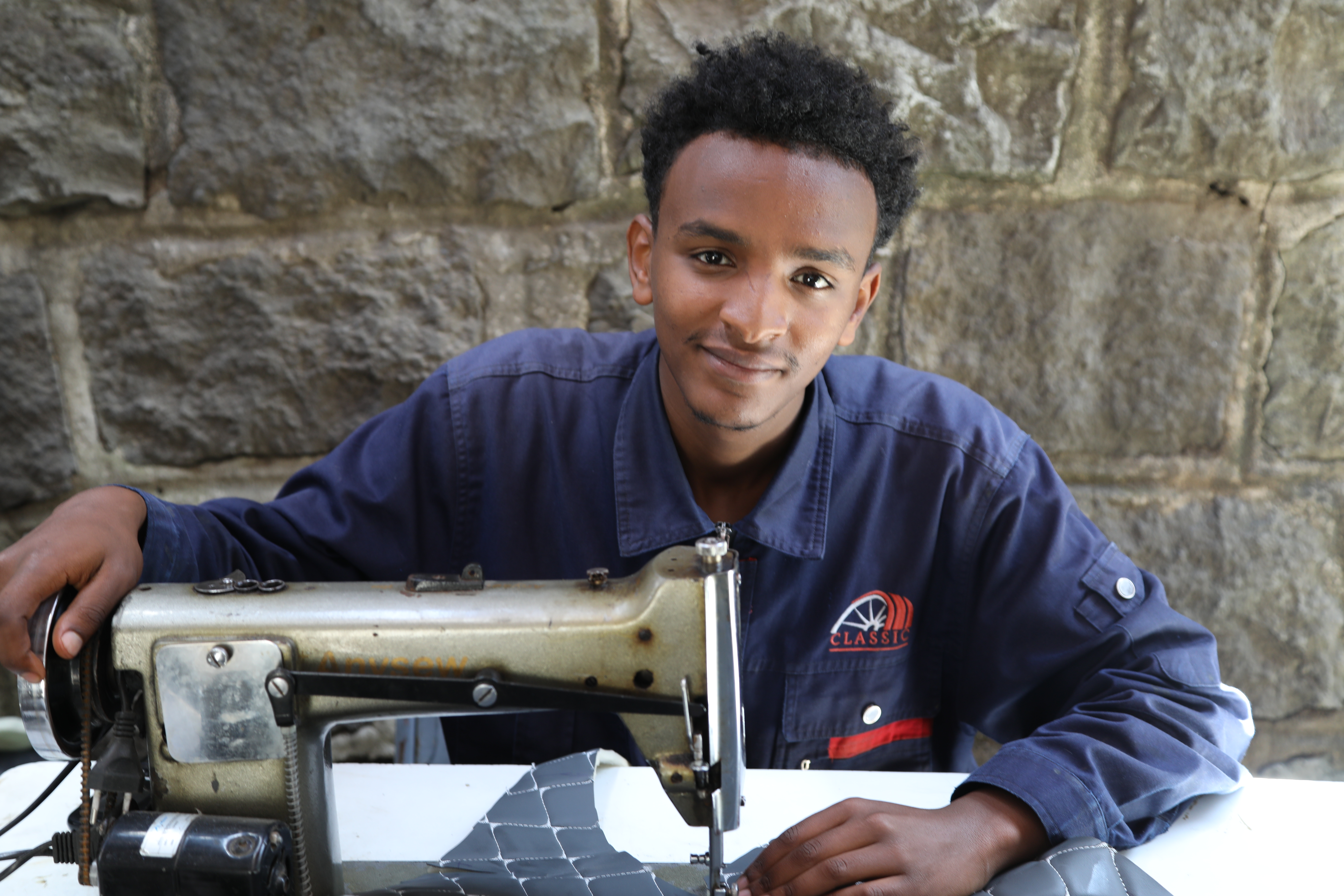 A young man learns tailoring as part of ChildFund Ethiopia’s vocational training program to support youth livelihoods.