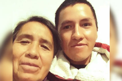 Close-up shot of a smiling young man, his mother in Bolivia