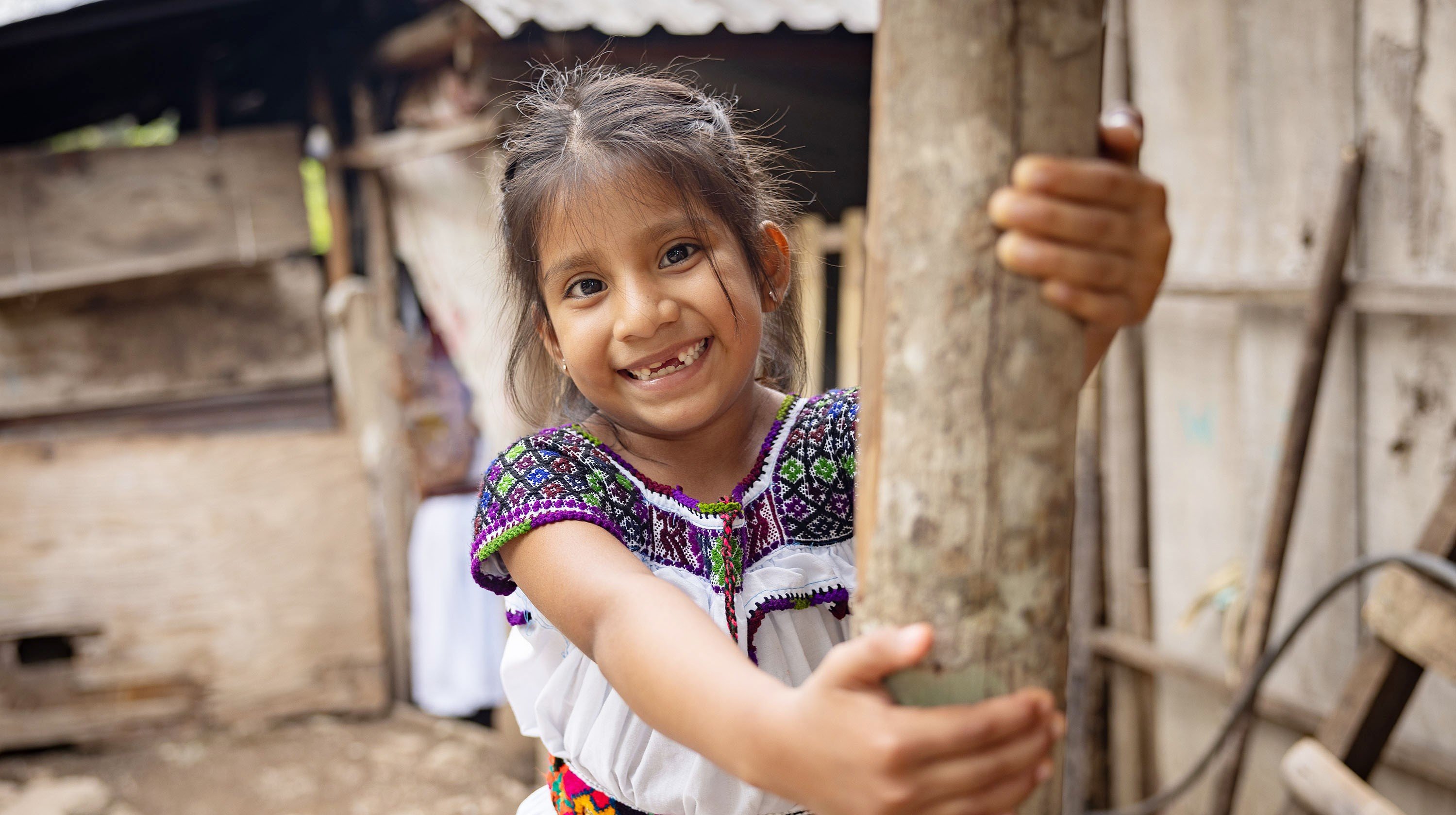 A young girl in Mexico smiles at the camera