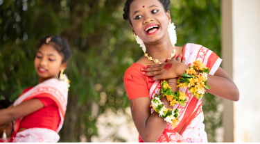 Young women in traditional Indian attire performing a joyful cultural dance, symbolizing heritage and celebration.