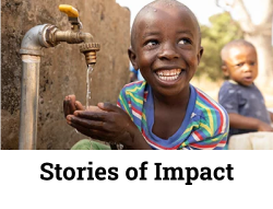  Smiling boy washing hands under a water tap, representing the impact of clean water access.